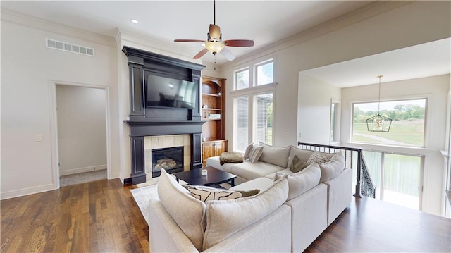 4301 N 141st St, Basehor, KS 66007 - living area featuring a ceiling fan, crown molding, a fireplace, baseboards, and dark wood finished floors