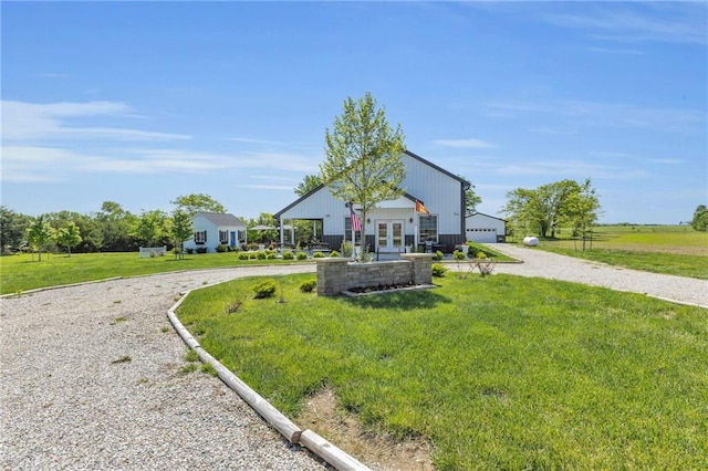 back of house with french doors, a lawn, and curved driveway