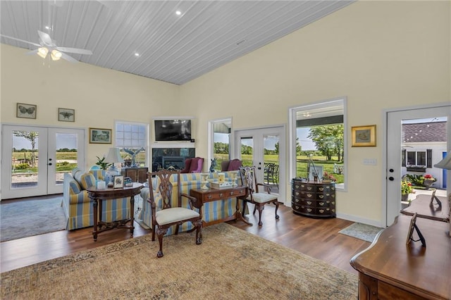 living room featuring french doors, high vaulted ceiling, a ceiling fan, wood finished floors, and baseboards