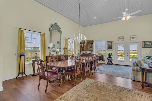 dining space with french doors, wood finished floors, healthy amount of natural light, a chandelier, and a high ceiling
