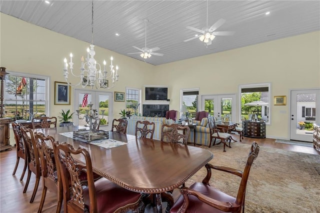 dining room with french doors, wood finished floors, a towering ceiling, a chandelier, and recessed lighting