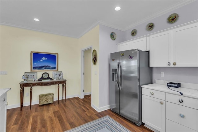 kitchen featuring stainless steel refrigerator with ice dispenser, ornamental molding, white cabinets, dark wood finished floors, and baseboards