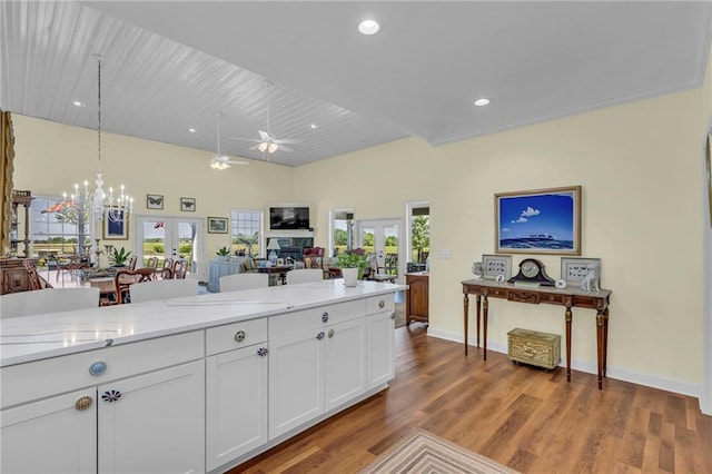kitchen featuring french doors, ceiling fan, white cabinetry, a chandelier, and decorative light fixtures
