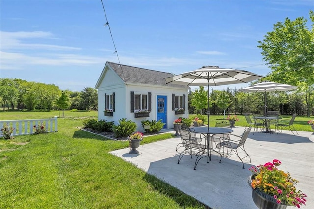 view of patio with an outbuilding and outdoor dining space