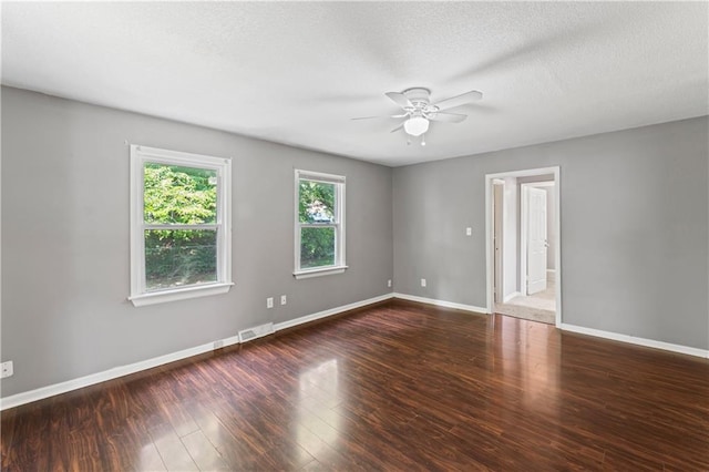 spare room with a ceiling fan, wood finished floors, baseboards, and a textured ceiling