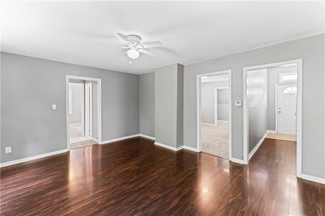 unfurnished living room with ceiling fan, baseboards, and wood finished floors