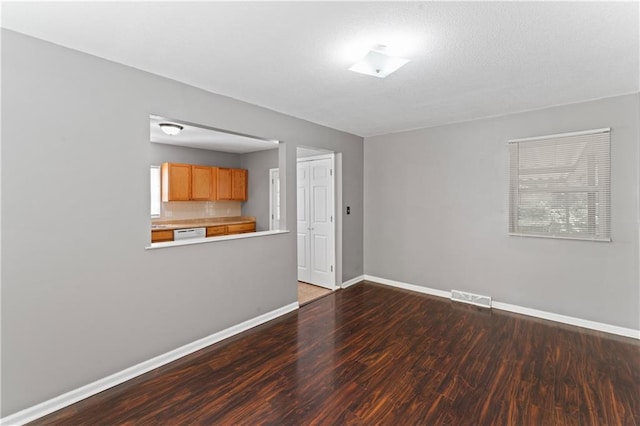 unfurnished living room featuring wood finished floors and baseboards