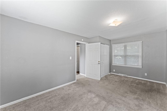unfurnished bedroom featuring carpet, baseboards, and a closet