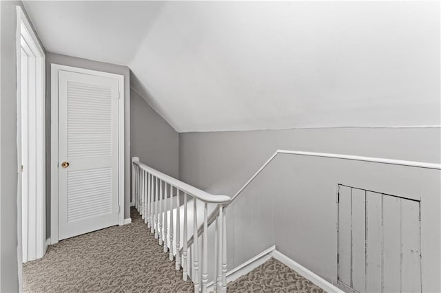 staircase featuring vaulted ceiling, carpet floors, and baseboards