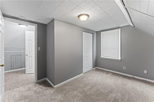 additional living space with carpet floors, baseboards, and vaulted ceiling