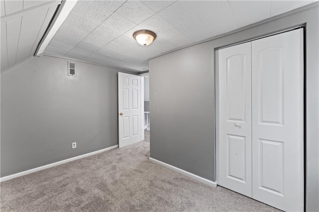 unfurnished bedroom featuring carpet, a closet, and baseboards