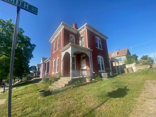 432 S 5th St, Atchison, KS 66002 - view of front of property with covered porch, a front yard, and a chimney