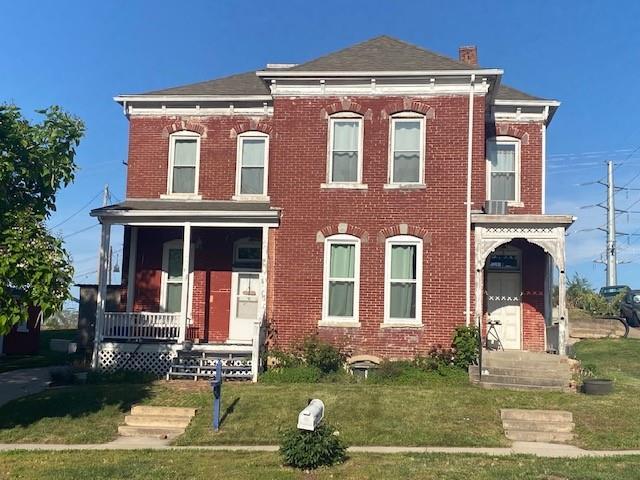 432 S 5th St, Atchison, KS 66002 - view of front of property with brick siding, a front yard, and covered porch