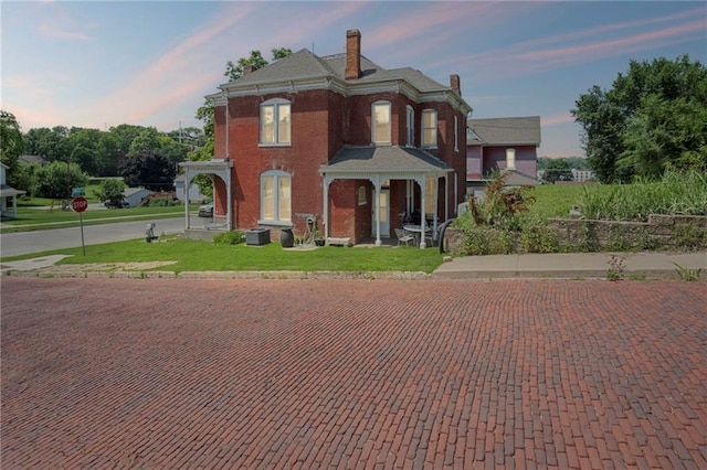 432 S 5th St, Atchison, KS 66002 - italianate-style house with a chimney, a lawn, and brick siding