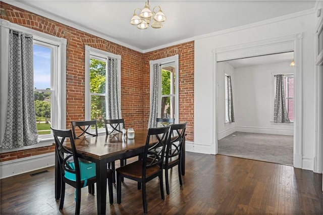 432 S 5th St, Atchison, KS 66002 - dining area with a chandelier, dark wood-style flooring, ornamental molding, and brick wall