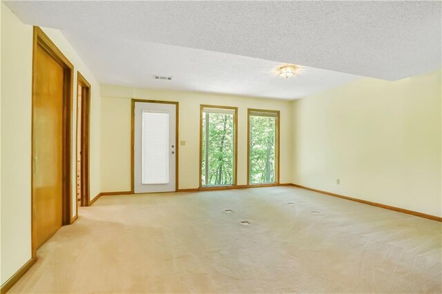 6503 NW Sioux Ct, Parkville, MO 64152 - spare room with light colored carpet, baseboards, and a textured ceiling