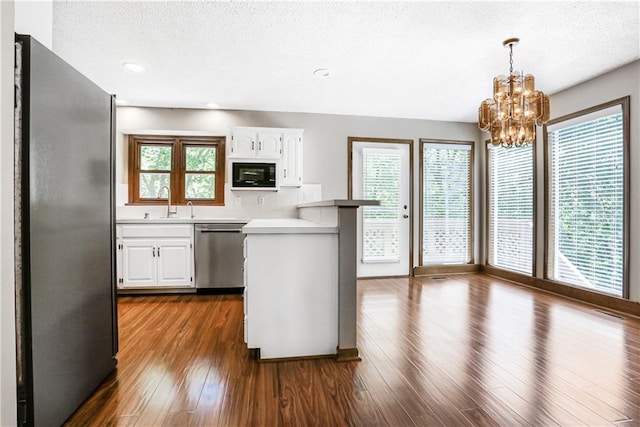 6503 NW Sioux Ct, Parkville, MO 64152 - kitchen with stainless steel appliances, white cabinetry, a chandelier, a peninsula, and a textured ceiling