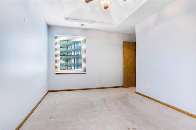 6503 NW Sioux Ct, Parkville, MO 64152 - spare room with carpet, a tray ceiling, a ceiling fan, and baseboards