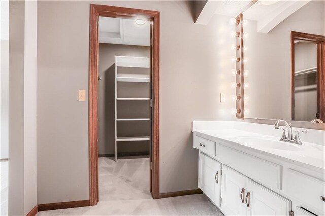 6503 NW Sioux Ct, Parkville, MO 64152 - bathroom featuring vanity, baseboards, and a spacious closet