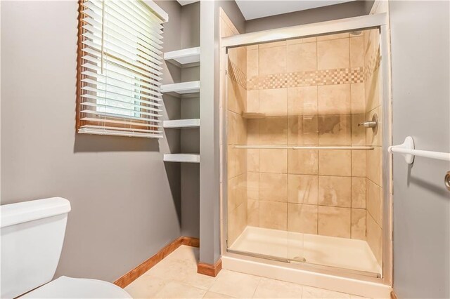 6503 NW Sioux Ct, Parkville, MO 64152 - bathroom with toilet, tile patterned floors, a shower stall, and baseboards