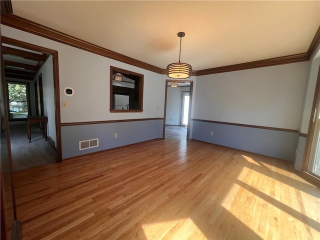 5806 N Kensington Ave, Kansas City, MO 64119 - unfurnished dining area with light wood finished floors, ornamental molding, and baseboards