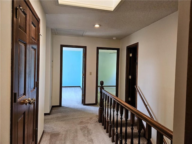 5806 N Kensington Ave, Kansas City, MO 64119 - hall with light carpet, attic access, an upstairs landing, and baseboards
