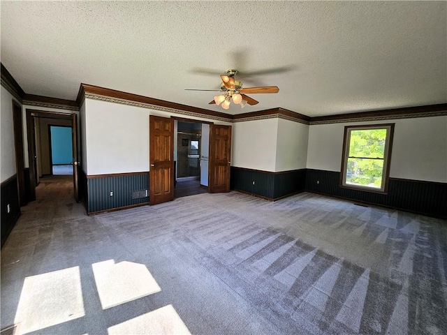 5806 N Kensington Ave, Kansas City, MO 64119 - carpeted spare room featuring wainscoting, a textured ceiling, ornamental molding, and a ceiling fan