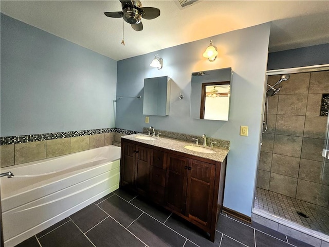 5806 N Kensington Ave, Kansas City, MO 64119 - bathroom with tile patterned floors, ceiling fan, a garden tub, a tile shower, and double vanity