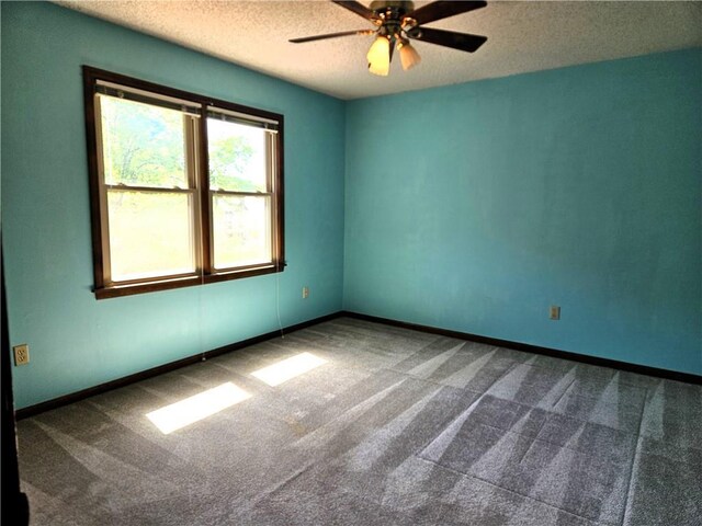 5806 N Kensington Ave, Kansas City, MO 64119 - empty room with dark colored carpet, a textured ceiling, ceiling fan, and baseboards