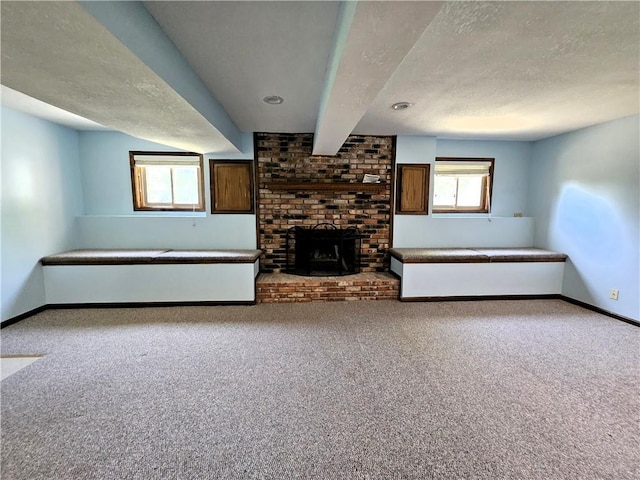 5806 N Kensington Ave, Kansas City, MO 64119 - unfurnished living room with a textured ceiling, baseboards, carpet flooring, beam ceiling, and a fireplace