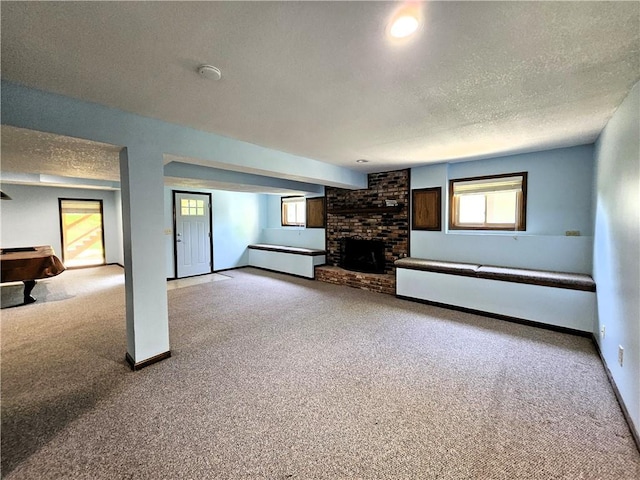 5806 N Kensington Ave, Kansas City, MO 64119 - unfurnished living room with carpet, a fireplace, baseboards, and a textured ceiling