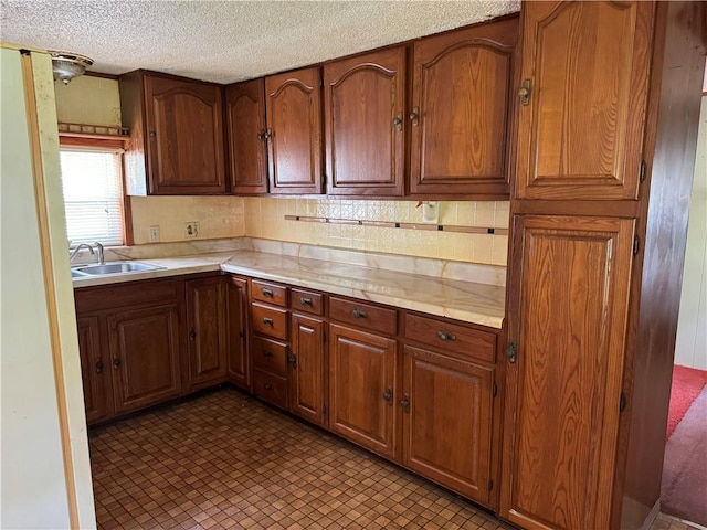 32572 Magnolia Ln, Excelsior Springs, MO 64024 - kitchen with a sink, light countertops, a textured ceiling, and brown cabinetry