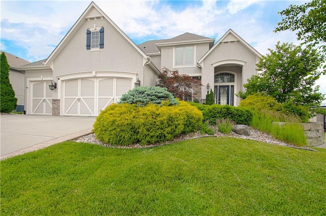 1110 Metfield Ln, Raymore, MO 64083 - view of front of home featuring a front lawn, stucco siding, and driveway