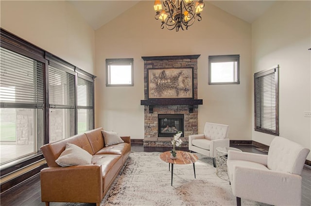 1110 Metfield Ln, Raymore, MO 64083 - living room featuring a chandelier, a fireplace, dark wood-style floors, high vaulted ceiling, and baseboards
