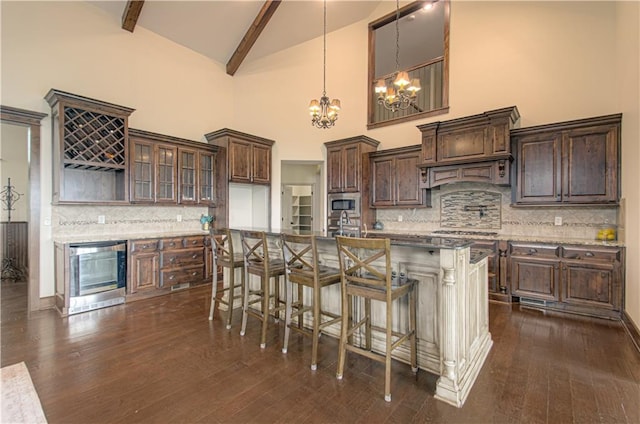 1110 Metfield Ln, Raymore, MO 64083 - kitchen featuring appliances with stainless steel finishes, high vaulted ceiling, wine cooler, a chandelier, and backsplash