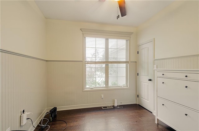 1110 Metfield Ln, Raymore, MO 64083 - spare room with a wainscoted wall, a ceiling fan, and dark wood-style flooring