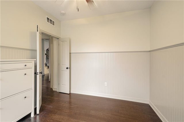 1110 Metfield Ln, Raymore, MO 64083 - unfurnished room featuring a wainscoted wall, dark wood finished floors, a ceiling fan, and baseboards