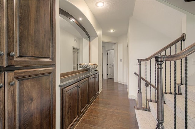 1110 Metfield Ln, Raymore, MO 64083 - corridor with dark wood-style flooring, arched walkways, baseboards, recessed lighting, and stairs