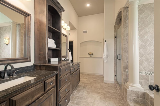 1110 Metfield Ln, Raymore, MO 64083 - full bathroom with ornate columns, vanity, a stall shower, stone finish flooring, and baseboards