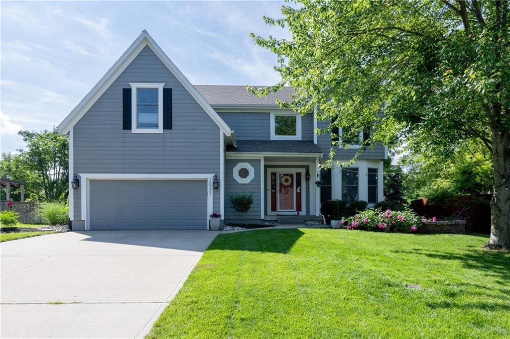15221 W 139th Ter, Olathe, KS 66062 - view of front of home featuring an attached garage, a front lawn, driveway, and a shingled roof