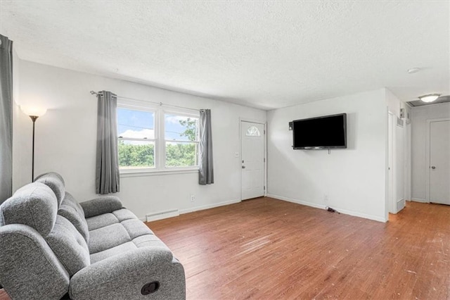 9021 E 79th St, Raytown, MO 64138 - living area featuring a textured ceiling, light wood-style flooring, and baseboard heating
