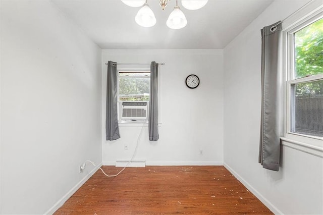 9021 E 79th St, Raytown, MO 64138 - unfurnished room with a chandelier, plenty of natural light, cooling unit, and wood finished floors