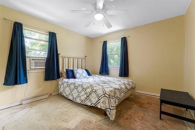 9021 E 79th St, Raytown, MO 64138 - bedroom featuring a baseboard heating unit, multiple windows, hardwood / wood-style floors, and a ceiling fan