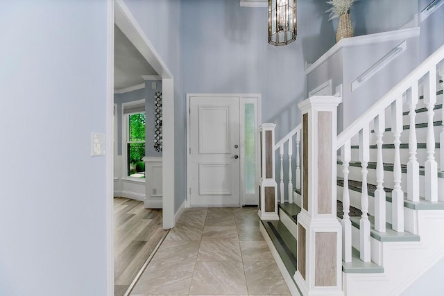 11506 Knox St, Overland Park, KS 66210 - entrance foyer with stairway, a towering ceiling, crown molding, and a chandelier