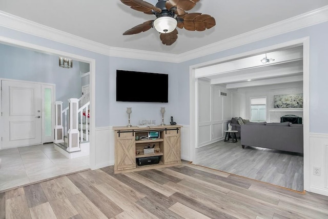 11506 Knox St, Overland Park, KS 66210 - living area with light wood-style floors, stairway, a decorative wall, ceiling fan, and wainscoting