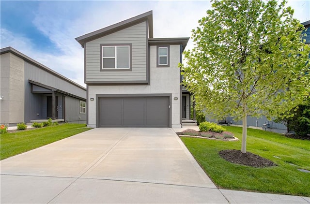 contemporary house featuring an attached garage, a front yard, driveway, and stucco siding