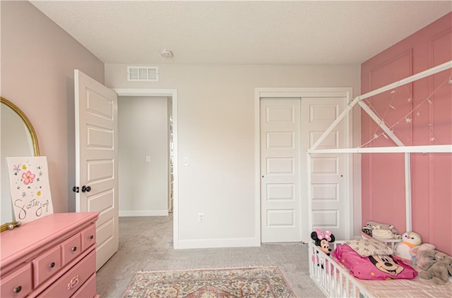 bedroom with light colored carpet, a closet, baseboards, and a textured ceiling