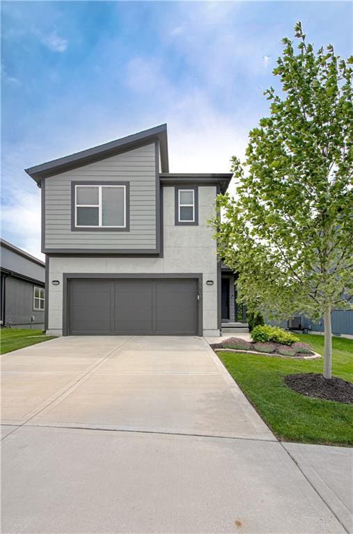 18061 W Hauser St, Overland Park, KS 66013 - view of front of home featuring an attached garage, driveway, and a front lawn