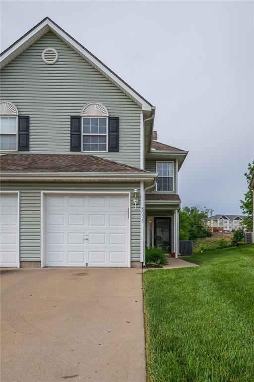 8008 NE Elmwood Ave, Kansas City, MO 64119 - traditional-style house featuring driveway, a front yard, an attached garage, and cooling unit