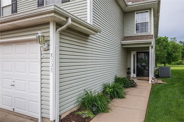 8008 NE Elmwood Ave, Kansas City, MO 64119 - doorway to property featuring a garage, a lawn, and cooling unit